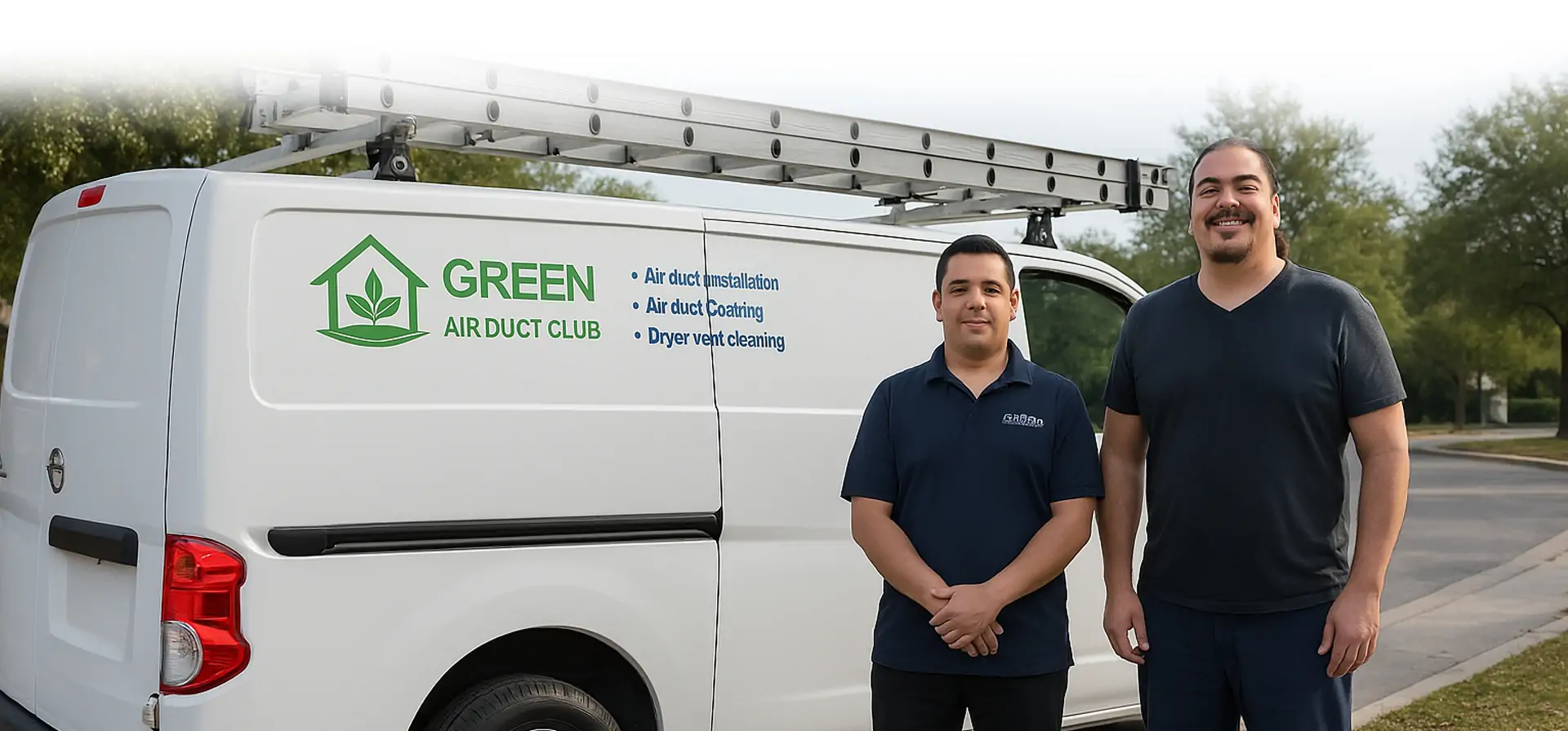 Two male service technicians stand in front of a white service van branded with "Green Air Duct Club" in green lettering. The van displays services offered including air duct installation, air duct coating, and dryer vent cleaning, and is equipped with a roof-mounted ladder rack. Both men are wearing dark colored polo shirts and smiling at the camera in what appears to be a residential neighborhood.